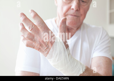 Ältere Mann mit Bandage am Handgelenk Stockfoto