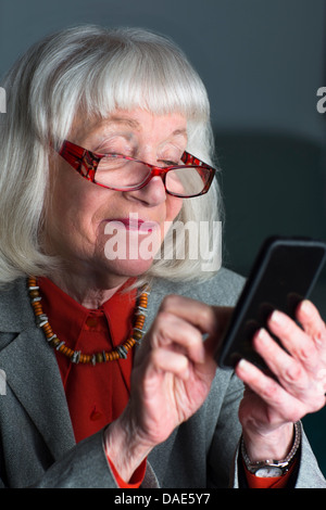 Ältere Frau mit smartphone Stockfoto