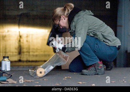 Ein Offizier der deutschen staatlichen Untersuchung Bureau LKA sichert Beweise für eine angebliche Brandsatz in Berlin, Deutschland, 15. November 2011. Ein Hausmeister einen Behälter mit einer Flüssigkeit neben einem Blatt Papier beschriftet mit extremen Rechten Parolen am Eingang einer Tiefgarage am 07:30 gefunden. Wetter das Fundstück ist eine unbeleuchtete Brandsatz, stil Stockfoto