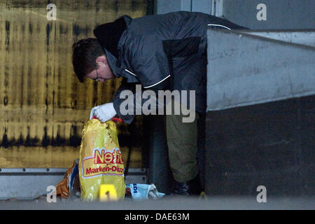 Ein Offizier der deutschen staatlichen Untersuchung Bureau LKA sichert Beweise für eine angebliche Brandsatz in Berlin, Deutschland, 15. November 2011. Ein Hausmeister einen Behälter mit einer Flüssigkeit neben einem Blatt Papier beschriftet mit extremen Rechten Parolen am Eingang einer Tiefgarage am 07:30 gefunden. Wetter das Fundstück ist eine unbeleuchtete Brandsatz, stil Stockfoto