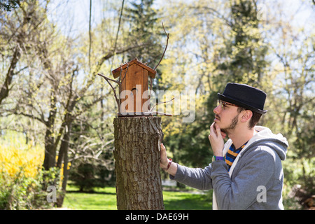 Man sah Vogelhaus mit Hand am Kinn Stockfoto