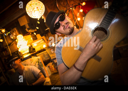 Mann mit Hut und Sonnenbrille, Gitarre spielen Stockfoto