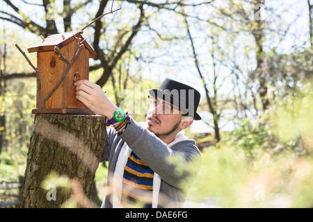 Mann sucht im Vogelhaus Stockfoto