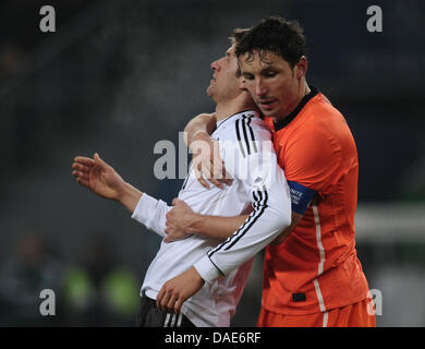 Holländische Mark van Bommel (R) umarmt Deutschlands Thomas Mueller während der internationalen Freundschaftsspiel Deutschland Vs Niederlande Imtech Arena in Hamburg, Deutschland, 15. November 2011. Foto: Christian Charisius Dpa/Lno +++(c) Dpa - Bildfunk +++ Stockfoto