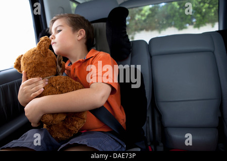 Blick aus dem Autofenster halten Teddybär junge Stockfoto