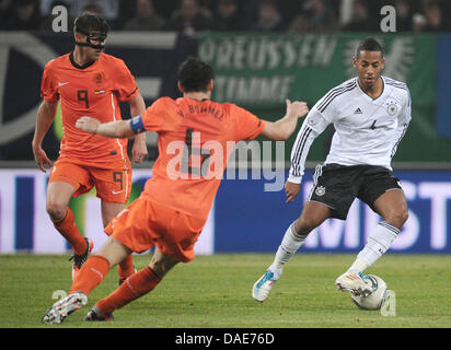 Deutschlands Dennis Aogo (R) steuert den Ball neben niederländischen Mark van Bommel (C) und Klaas-Jan Huntelaar (L) während der internationalen Fußball-freundliche Spiel Deutschland Vs Niederlande Imtech Arena in Hamburg, Deutschland, 15. November 2011. Foto: Christian Charisius Dpa/lno Stockfoto