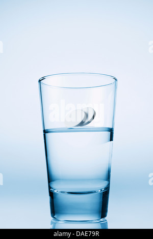 Tabletten in Glas Wasser fallen Stockfoto