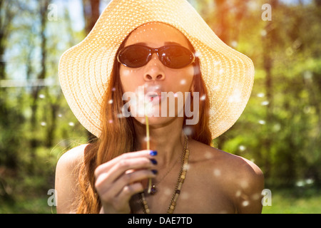 Frau bläst Löwenzahn Uhr Stockfoto