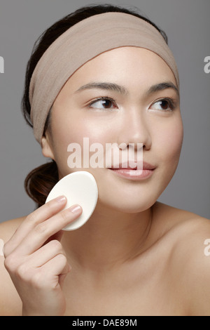 Junge Frau mit Make-up Schwamm Stockfoto