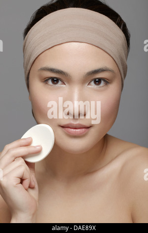 Junge Frau mit Make-up Schwamm Stockfoto