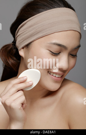 Junge Frau mit Make-up Schwamm Stockfoto