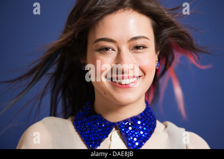 Porträt der jungen Frau mit gefärbten Haaren und blauen Pailletten Kragen Stockfoto