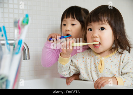 Zwei Mädchen Kleinkinder Zähneputzen im Badezimmer Waschbecken Stockfoto