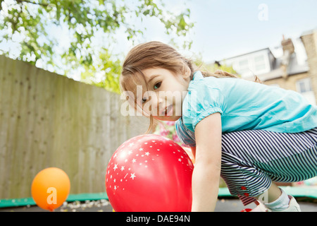 Junge Mädchen spielen im Garten mit Luftballons Stockfoto