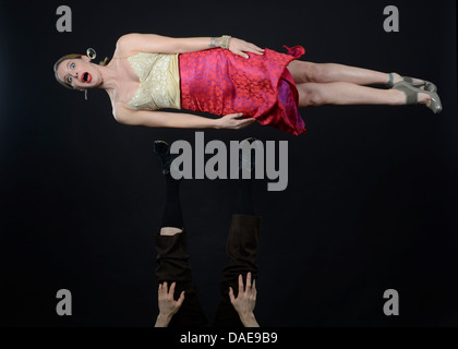 Studioaufnahme von weiblichen Acrobat Mitte Luft, auf der Seite liegend Stockfoto