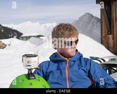 Skifahrer mit einer GoPro-Kamera montiert auf einen Skihelm im Gite du Lac de Gers Restaurant im Le Grand Massif. Sixt, Samoens, Frankreich Stockfoto