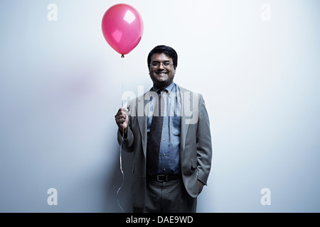 Studio-Porträt der Geschäftsmann mit roten Ballon Stockfoto
