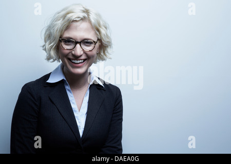 Studio-Porträt der blonden Geschäftsfrau lächelnd Stockfoto