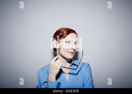 Studio-Porträt der jungen Frau mit Brille Stockfoto