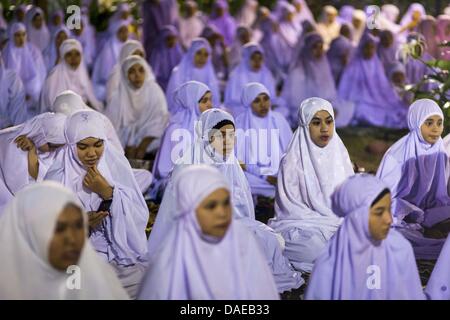 Pattani, Thailand. 11. Juli 2013. Frauen beten außerhalb von Pattani Zentralmoschee Donnerstag Nacht nach Ramadan Dienstleistungen. Die Moschee ist einer der verkehrsreichsten in Süd-Thailand. Nächtliche Ramadan Gottesdienste in die Moschee besuchen etwa 15.000 Menschen. Ramadan ist der neunte Monat des islamischen Kalenders, und zeigte sich der Monat, in dem Muslime den Koran zu glauben. Muslime glauben, dass der Koran in diesem Monat herabgesandt wurde, somit vorbereitet für schrittweise Offenbarung durch Jibraeel (Gabriel) dem Propheten Muhammad. Bildnachweis: ZUMA Press, Inc./Alamy Live-Nachrichten Stockfoto