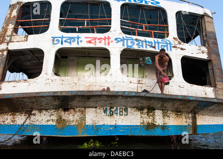 Eine Besatzung von einem Fluss Fähre oder Start waschen mit Eimern und Flusswasser bei Sadarghat am Fluss Buriganga in Dhaka, Bangladesch. Stockfoto