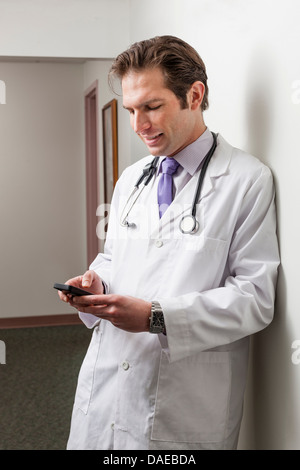 Arzt mit Handy im Krankenhausflur Stockfoto