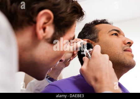 Mitte Erwachsenen Arzt Otoskop auf Patienten mit Stockfoto