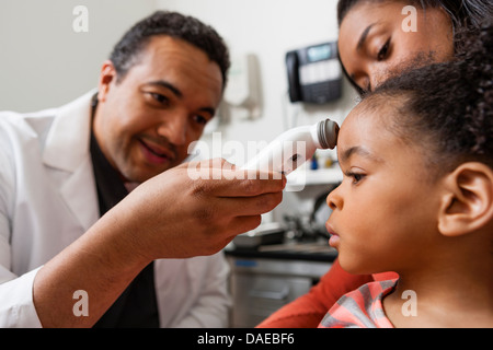 Mitte Erwachsenen Arzt über medizinische Geräte auf junge Patienten Stockfoto