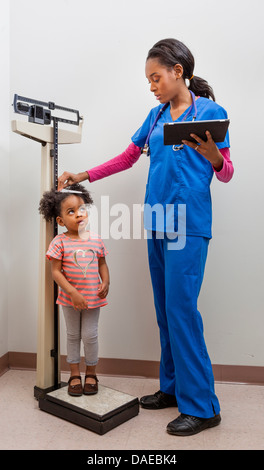 Krankenschwester, die Messung der Höhe der jungen Patienten Stockfoto