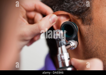 Mitte Erwachsenen Arzt Otoskop auf Patienten mit Stockfoto