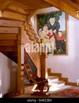 Handgefertigte Holztreppe mit Beryl Cook Gemälde an die Wand im Alpine Chalet Halle mit einfachen Holzstuhl Stockfoto