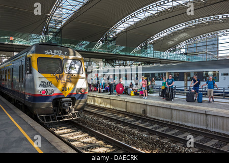 Touristen mit Koffern und Rucksacktouristen im Urlaub warten auf Plattform für Zug am Bahnhof in den Sommerferien Stockfoto