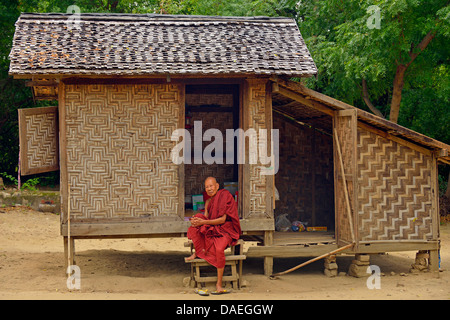 alten Mönch auf der Treppe von seinem bescheidenen Holzhaus, Burma, Mandalay Stockfoto