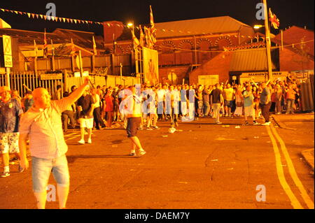 Belfast, UK. 11. Juli 2013. Am 11. Juli werden standhaft protestantischen Gebieten "Elfte Nacht" Freudenfeuer angezündet. Viele sind massive Konstruktionen aus Holz Paletten, alte Sofas und Gummireifen, garniert mit irischen Fahnen oder Bildnisse von pro-Nationalist zahlen. Lagerfeuer Architekten Schlacht es sehen, wer der größte aufbauen kann und Verschiebungen der junge Wächter sicherzustellen, dass die rivalisierende Bauherren nicht brennbarer Beute stehlen. Um Mitternacht sind die Freudenfeuer angezündet, und diesen rasenden Infernos sehen lodernden quer durch die Stadt - die Shankill Road und Milltown Road (South Belfast) Lagerfeuer sind zwei der größten Belfasts. Stockfoto