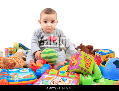 Baby-sitting in einem Haufen von Spielsachen Stockfoto