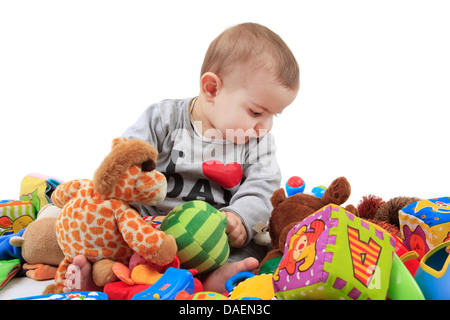 Baby-sitting in einem Haufen von Spielsachen Stockfoto