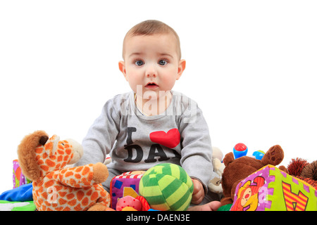 Baby-sitting in einem Haufen von Spielsachen Stockfoto