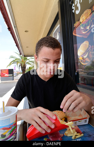 Ein 18-j hrige Mann isst Fast Food. Stockfoto