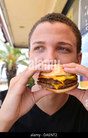 Ein 18-j hrige Mann isst Fast Food. Stockfoto