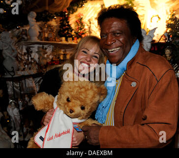 Folk-Sänger Roberto Blanco und seine Frau Roberto Blanco Und Seine Frau Luzandra Strassburg posieren mit einem Teddybär während der Voreröffnung des Weihnachtsmarktes auf dem Anwesen Gut Aiderbichl nahe Salzburg, Österreich, 17. November 2011. Gut Aiderbichl beherbergt Tiere, die eine traurige Vergangenheit hatte. Das Anwesen feiert sein 10-jähriges Jubiläum. Foto: Volker Dornberger Stockfoto
