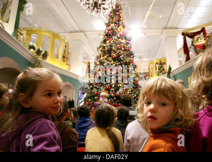 Kinder sitzen vor einem riesigen Weihnachtsbaum während der Eröffnung der Weihnachtsverkauf im Kaufhaus KaDeWe (Kaufhaus des Westens) in Berlin, Deutschland, 22. November 2011 (im Bild mit Zoom-Effekt). Der Eingangsbereich des Ladens ist unter dem Motto "Weihnachten wie im Märchen" eingerichtet. Foto: STEPHANIE PILICK Stockfoto