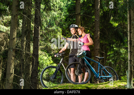 Lächelnde Teen Radfahrer zeigen und stehen Stockfoto