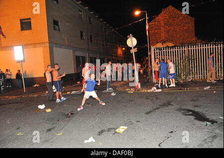 Belfast, Nordirland. 11. Juli 2013. Am 11. Juli werden standhaft protestantischen Gebieten "Elfte Nacht" Freudenfeuer angezündet. Viele sind massive Konstruktionen aus Holz Paletten, alte Sofas und Gummireifen, garniert mit irischen Fahnen oder Bildnisse von pro-Nationalist zahlen. Lagerfeuer Architekten Schlacht es sehen, wer der größte aufbauen kann und Verschiebungen der junge Wächter sicherzustellen, dass die rivalisierende Bauherren nicht brennbarer Beute stehlen. Um Mitternacht die Freudenfeuer angezündet werden, und diese wütenden Infernos lodernden quer durch die Stadt zu sehen. Im Bild: Sandy Row Lagerfeuer. Bildnachweis: Andrew Chittock/Alamy Live-Nachrichten Stockfoto