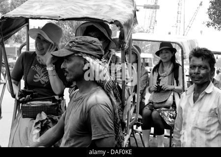 Ein Zyklus-Rikscha-Fahrer mit ausländischen Touristen in New Delhi, Indien Stockfoto