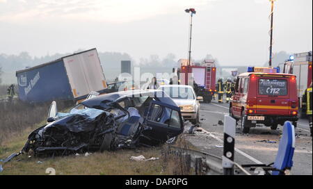 Rettungsassistenten stehen neben einem zerstörten Auto auf der Bundesstraße 4 in der Nähe von Uelzen, Deutschland, 23. November 2011. Bei einer Kollision eines LKW und zwei Autos hat einen weiblichen Autofahrer getötet worden. Foto: Philipp Schulze Stockfoto