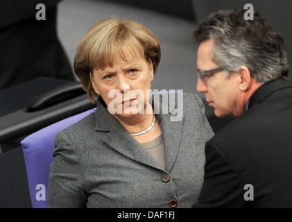 Bundeskanzlerin Angela Merkel plaudert mit deutschen Verteidigung Minister Thomas de Maiziere im Bundestag in Berlin, Deutschland, 25. November 2011. Heute stimmt der Bundestag über den Haushaltsplan 2012. Foto: RAINER JENSEN Stockfoto