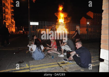 Belfast, Nordirland. 11. Juli 2013. Am 11. Juli werden standhaft protestantischen Gebieten "Elfte Nacht" Freudenfeuer angezündet. Viele sind massive Konstruktionen aus Holz Paletten, alte Sofas und Gummireifen, garniert mit irischen Fahnen oder Bildnisse von pro-Nationalist zahlen. Lagerfeuer Architekten Schlacht es sehen, wer der größte aufbauen kann und Verschiebungen der junge Wächter sicherzustellen, dass die rivalisierende Bauherren nicht brennbarer Beute stehlen. Um Mitternacht die Freudenfeuer angezündet werden, und diese wütenden Infernos lodernden quer durch die Stadt zu sehen. Im Bild: Sandy Row Lagerfeuer. Bildnachweis: Andrew Chittock/Alamy Live-Nachrichten Stockfoto