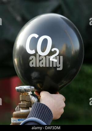 (DATEI) Eine Archivfoto vom 9. Oktober 2008 zeigt Aktivistin füllen eine CO2-Ballons für den Bauch ein "Dinosaurier-Kohle-Kraftwerk" vor den NRW-Landtag in Düsseldorf. Eine DIN A4-Papier mit einer Farbskala muss zeigen, wie gut die Energiebilanz eines Neuwagens von Donnerstag, 01 Dezember ab ist. Die deutsche Bundesregierung verspricht mehr Transparenz und bett Stockfoto