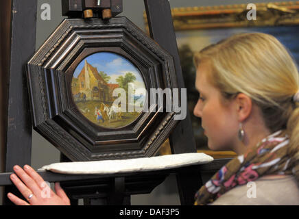 Die kreisförmige Paiting "vor der Dorfschenke' von Jan Brueghel der jüngeren (1601-1678) auf einer Staffelei nach seiner Rückkehr in den Zwinger nach 66 Jahren in Dresden, Deutschland, 20. November 2011 sitzt. 18,5 Zentimeter Durchmesser, Landschaftsmalerei von 1641 mit Planwagen, Pferde und Bauer vom Enkel des berühmten Malers Peter Brueghel der ältere ist eines der Meisterwerke-mis Stockfoto