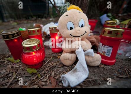 Ein Cuddl Spielzeug und Kerzen werden vor Mülltonnen im Stadtteil Buch in Berlin, Deutschland, 1. Dezember 2011 eingerichtet. Am 30. November 2011 fanden ein totes Kind in eines der Mülltonnen. Foto: Sebastian Kahnert Stockfoto